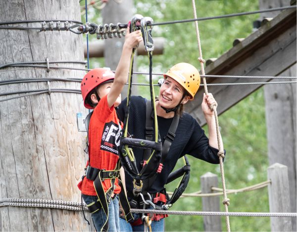 Eine Familie kelttert gemeinsam durch den Hochseilgarten