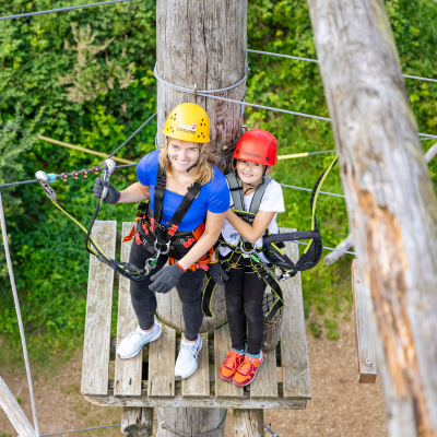 Klettern in der Hauptsaison Zwei lachende Kinder mit Helm