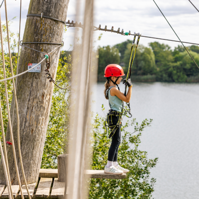 Kind steht auf dem Brett vor einer Seilbahn