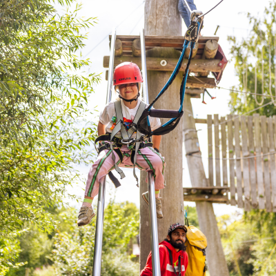 Kind rutscht von einem Kletterelement runter